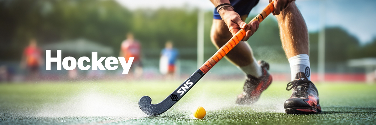 A male hockey player is playing field hockey A male hockey player is playing field hockey during daylight hours